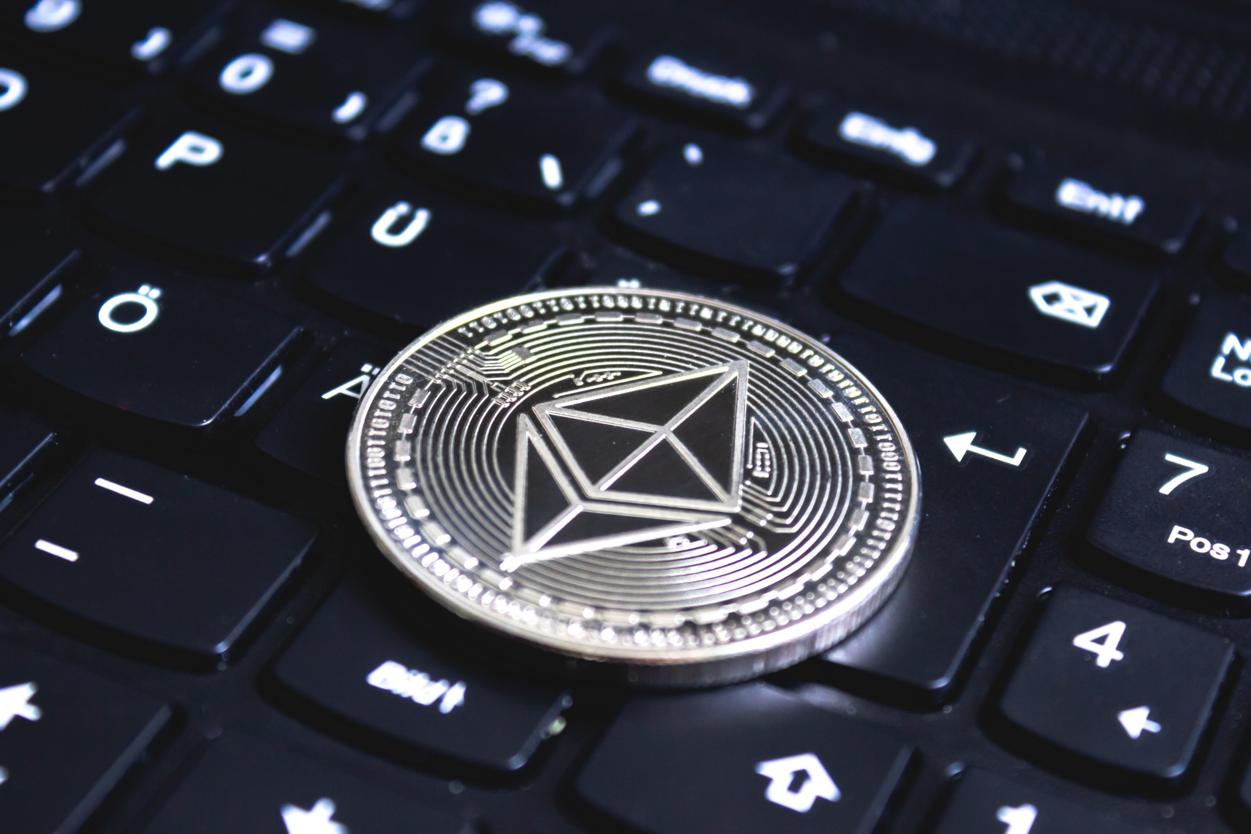 large coin placed on top of a black computer keyboard