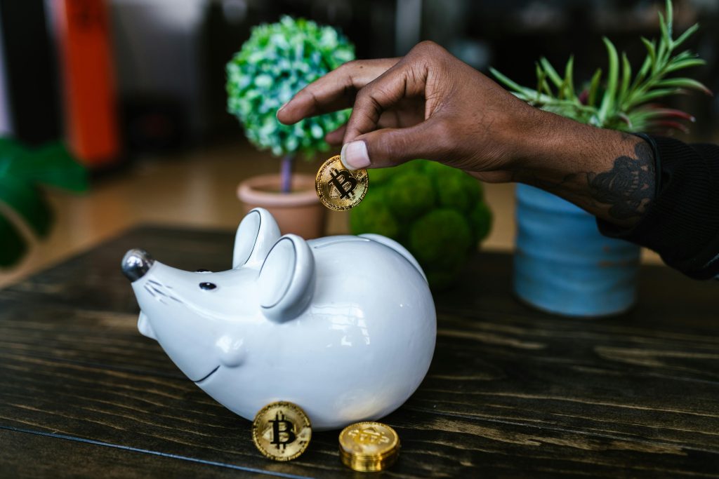 An image of crypto being deposited into a piggy bank