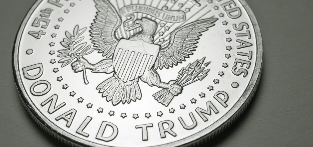 An image of a silver coin with "Donald Trump" written on the coin and ' president of the united state" written on the coin with an eagle in the middle.