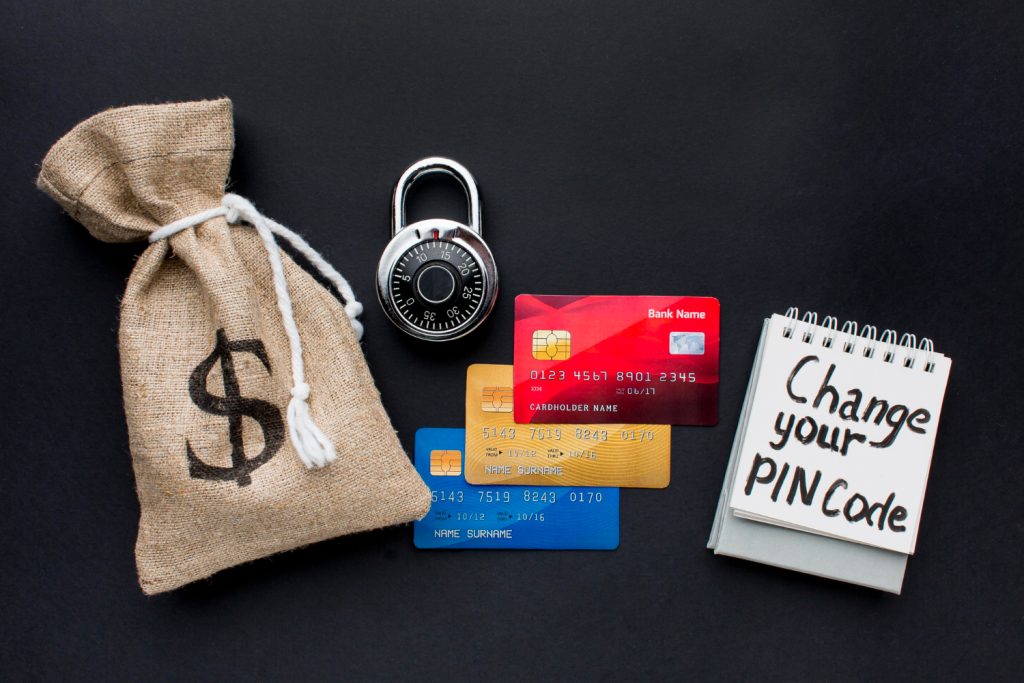 Illustration of a padlock, a bag of money, and bank cards representing financial security and safe transactions."